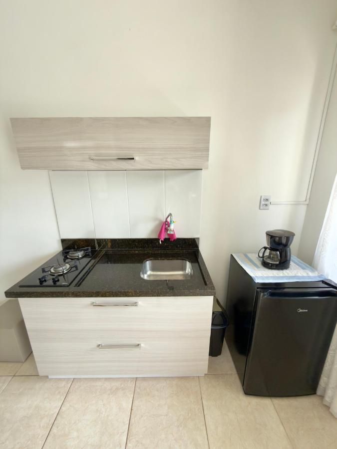 Cozinha compacta com cooktop, cafeteira e frigobar