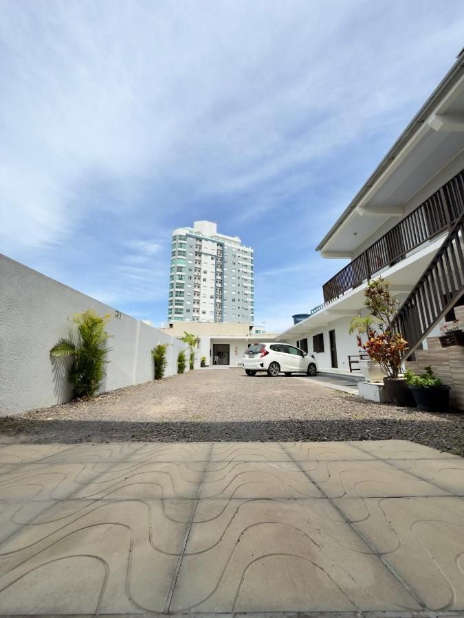 Pátio interno de estacionamento da pousada, com o prédio ao fundo